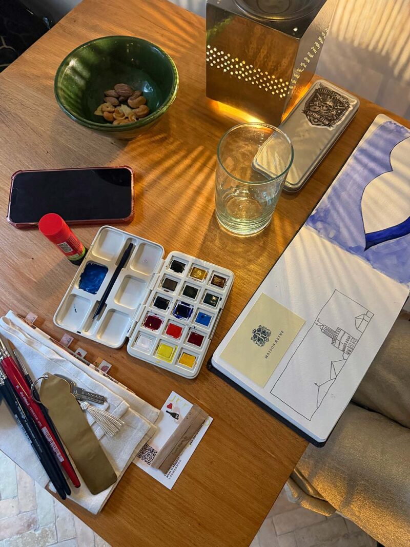 Aquarelverf, kwasten en een travel journal in de zon